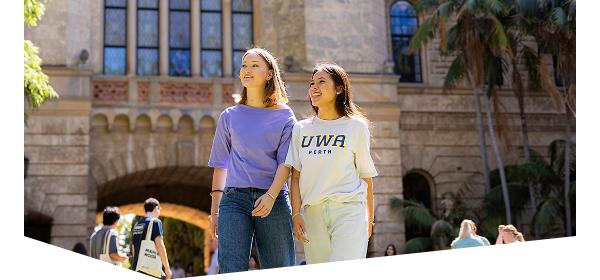 Two female students in front of Winthrop Hall with their bicycles