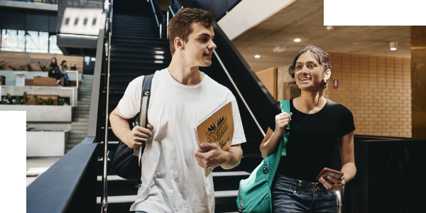 Two students, male and female, walking at the end of a staircase at EZONE UWA