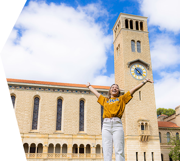 Female student with hands up in the air in front of Winthrop Hall