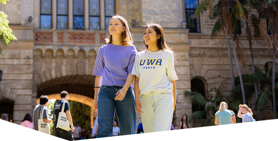 Two female students walking in front of Winthrop Hall