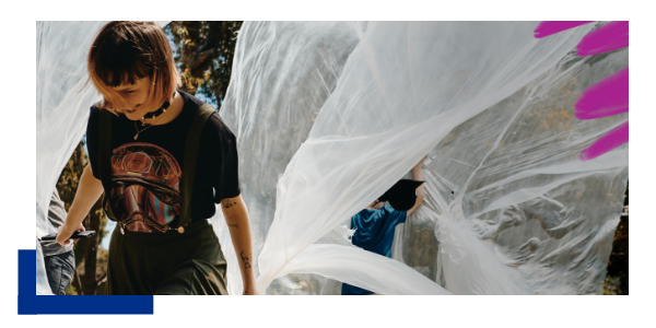 Student walking and holding flowing fabric